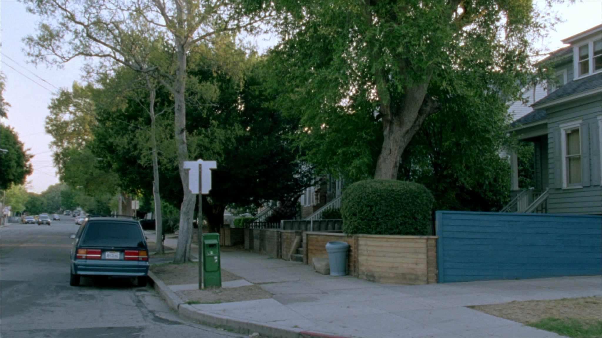 Quiet Toronto-style residential street in late-afternoon light, porches and maple trees