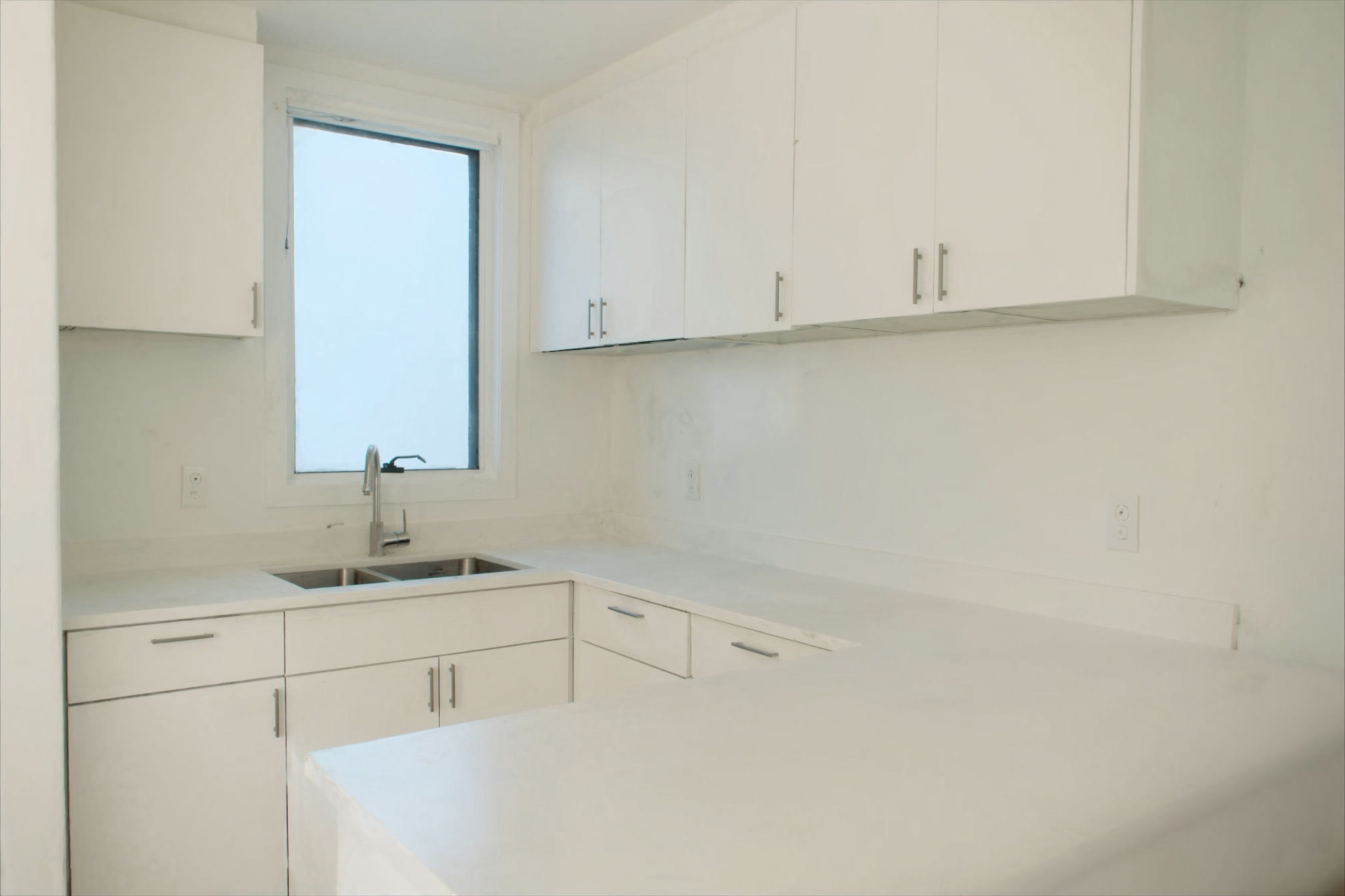 Small bright city condo kitchen and window, tidy and empty of people