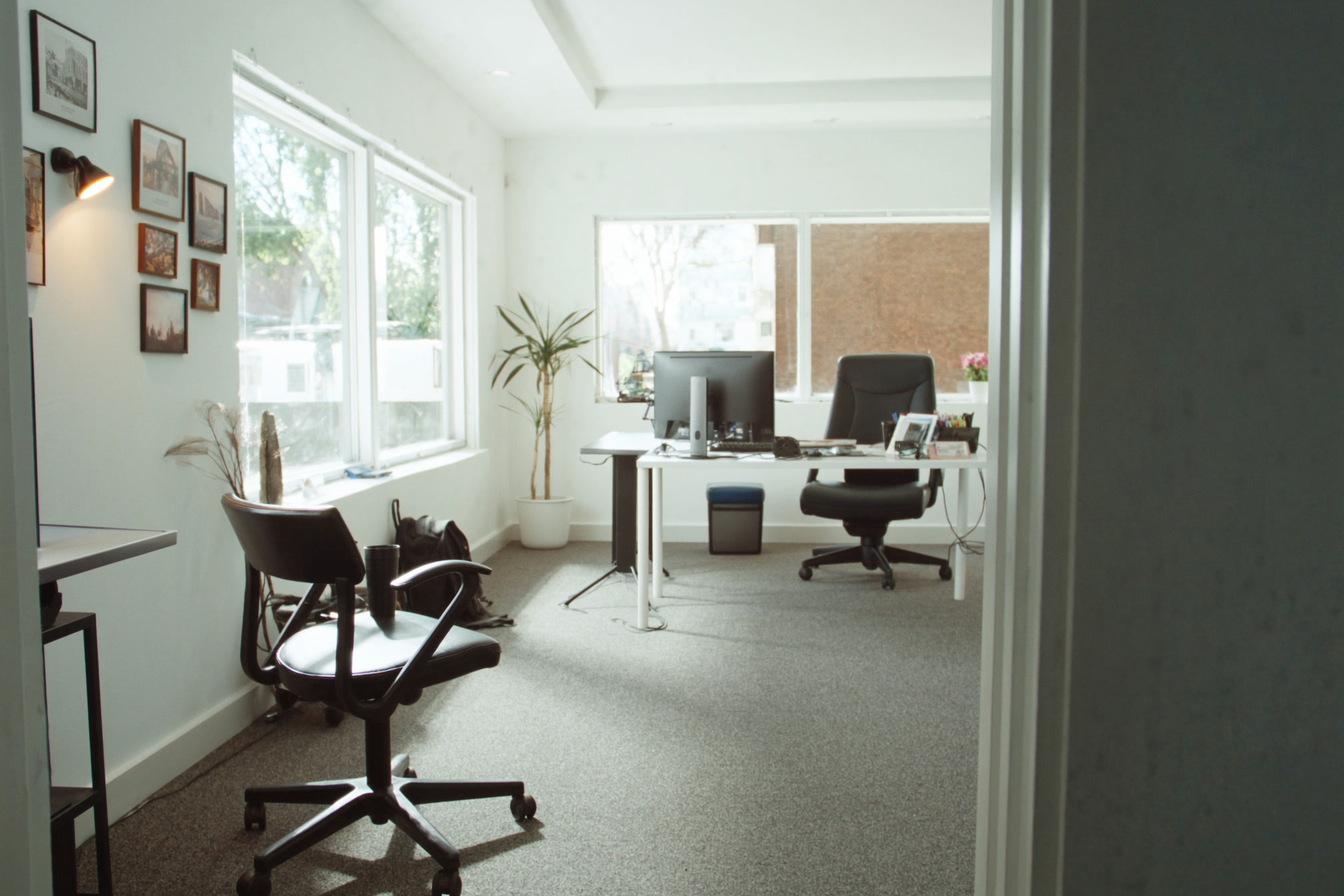 Small bright open-plan studio office with empty desks and a freshly vacuumed floor